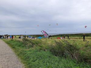 Nørbyにある6 person holiday home in Ringkøbing-By Traumの野原で凧揚げをしている人々のグループ