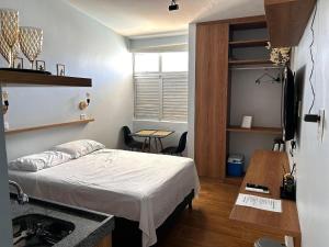 a bedroom with a bed and a desk and a table at Flats Sol e Brisa in Marechal Deodoro +13 photos