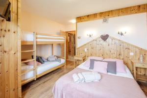 a bedroom with two bunk beds and a desk at Le Col Panoramic in La Toussuire