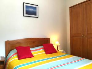 - une chambre avec un lit coloré et 2 oreillers rouges dans l'établissement Holidays Madeira, à São Vicente