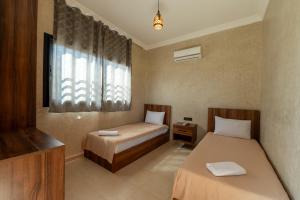 a bedroom with two beds and a window at Villa Mazigh & piscine in Marrakech +26 photos