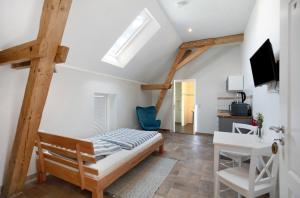 a bedroom with a bed and a desk and a window at Ferienhaus 'Zum tänzelnden Pony' in Ludwigsfelde