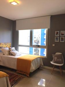 um quarto com uma cama e uma grande janela em Forest Tower 2 - Apartamento 305 em Punta del Este