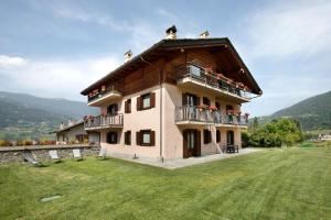 a large building with balconies on top of a field at Maison Le Cré Appartamento 3 in Introd