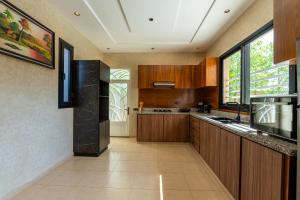 a kitchen with wooden cabinets and a large window at Villa Mazigh & piscine in Marrakech