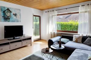 a living room with a couch and a tv at Am Sommerrain in Elzach