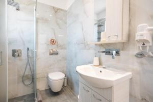 a bathroom with a toilet and a sink and a shower at Velvet Apartments in Kremasti +37 photos