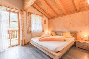 une chambre avec un lit et une grande fenêtre dans l'établissement Steineggerhof, à Valle Di Casies