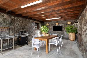 a dining room with a wooden table and chairs at Finca El Refugio in Teguise