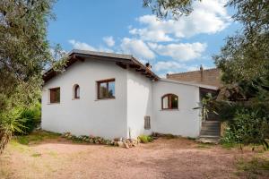 ein weißes Haus mit Bäumen davor in der Unterkunft Suite Harmony in Loiri