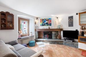 Appartamento nel borgo di Chatillon في شاتيلون: غرفة معيشة مع أريكة ومدفأة