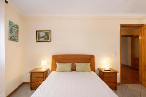 a bedroom with a bed with two night stands and two lamps at Xavega Apartment Torreira in Torreira