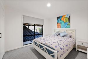 een witte slaapkamer met een bed en een raam bij Seahaven Views in Ventnor