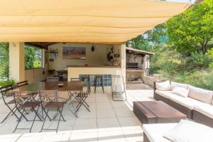 a patio with a couch and a table and chairs at Gite Provençal in Grospierres