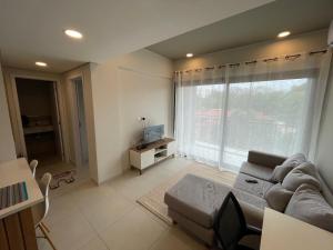 a living room with a couch and a large window at Washington Park Deptos in Asuncion