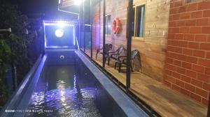 a pool in a building at night with chairs at Wasi ñusta Yaku in Archidona