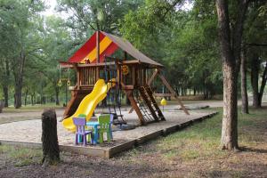 een speeltuin met een glijbaan en stoelen in een park bij Peach Cabin in Fredericksburg