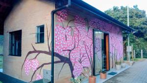 a mural of a tree on the side of a building at Sonho na Serra Chalé 2 in Gonçalves