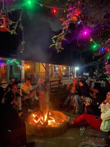 a group of people sitting around a fire at night at Pousada Holística Alto do Sol in Nova Friburgo