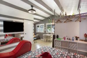 a living room with a red couch and a tv at Chalet Puerto Escondido in Telde