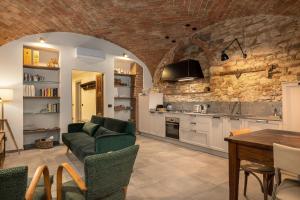 a living room with a green couch and a kitchen at Casa Masoni in Colle Val D'Elsa +16 photos