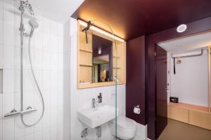 um banheiro com chuveiro, pia e vaso sanitário em VISIMO Apartments Zurich Airport em Kloten mais 33 fotografias