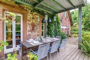 a patio with a table and chairs on a deck at Gutshof Kaiserbacher Mühle in Klingenmünster