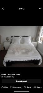 a bedroom with a bed with white sheets and pillows at The Black Lion in Bridlington