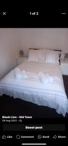 a bedroom with a bed with white sheets and pillows at The Black Lion in Bridlington