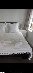 a bed with white sheets and pillows and a window at The Black Lion in Bridlington