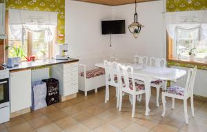 a kitchen with a white table and white chairs at Lovely Home In Kopparberg With Sauna in Kopparberg