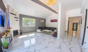un soggiorno con pavimenti in marmo bianco e lampadario pendente. di Villa RM a Ivišovo Greblje