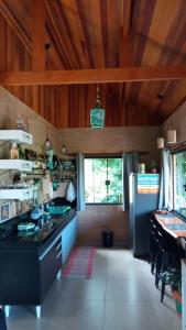 a kitchen with wooden ceilings and a counter top at Sonho na Serra Chalé 2 in Gonçalves