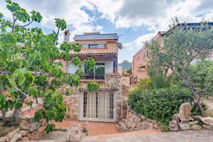 a house with a stone wall and a building at Villa Alfredo Golfo Aranci in Golfo Aranci