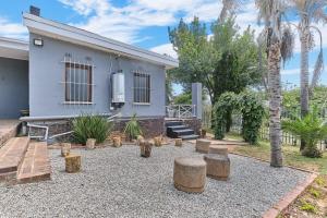 ein Hinterhof mit einem Haus, einigen Bäumen und Bänken in der Unterkunft The Cozy 1 bedroom apartment in Roodepoort