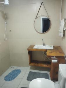 ein Badezimmer mit Waschbecken und Spiegel in der Unterkunft Casa inteira com pátio in Canela