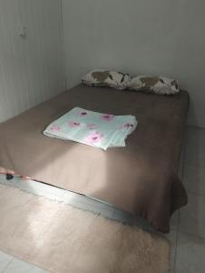 ein Bett mit einem Laken darüber in der Unterkunft Casa inteira com pátio in Canela