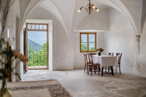 Un comedor con mesa y sillas y una ventana. en Ansitz Baumannhof Apt Erker Suite, en Falzes