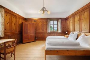 Un dormitorio con una cama, una mesa y un escritorio. en Ansitz Baumannhof Apt Erker Suite, en Falzes