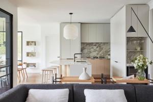 a living room with a couch and a kitchen at Calabash Bay Lodge in Berrilee +34 photos