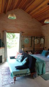 a bedroom with two beds and a couch and a window at Sonho na Serra Chalé 2 in Gonçalves