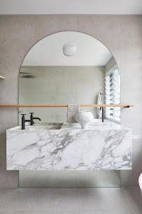 a bathroom with a marble sink and a mirror at Calabash Bay Lodge in Berrilee