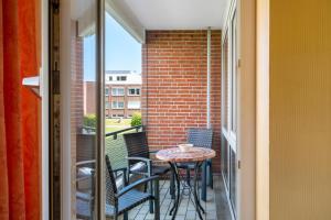 a small balcony with a table and chairs on it at Wellness Ferienwohnung Strandperle in Cuxhaven