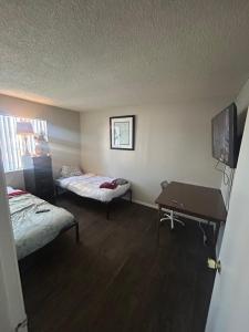 a room with two beds and a table in it at Cozy hostel for individuals in Phoenix