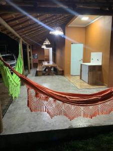 a hammock in the middle of a room at Casa às margens do Rio Caraíva, área verde in Caraíva