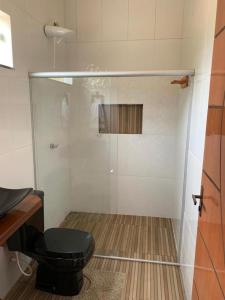 a bathroom with a glass shower with a toilet at Casa às margens do Rio Caraíva, área verde in Caraíva