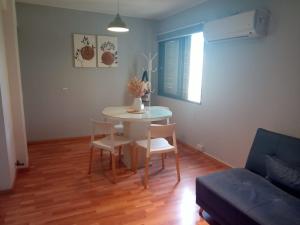 un salon avec une table, des chaises et un canapé dans l'établissement Cozy apartment, à Mendoza