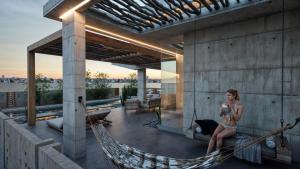 a woman sitting in a hammock on a house at Casa Arrecife in Talara