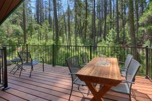 a wooden deck with chairs and a wooden table at 3 Springs Hideout - Family cabin with hot tub in Yosemite in South Wawona