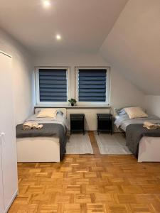 twee bedden in een kamer met twee ramen bij A6 Aparts in Garbsen